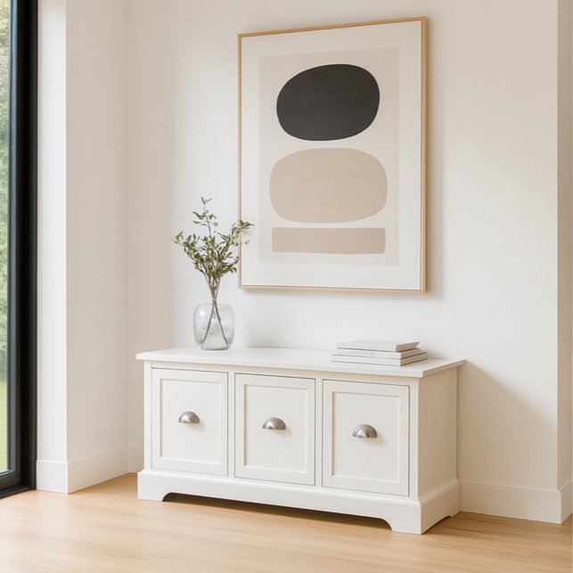 Modern living room with white cabinet, abstract art, and fireplace.